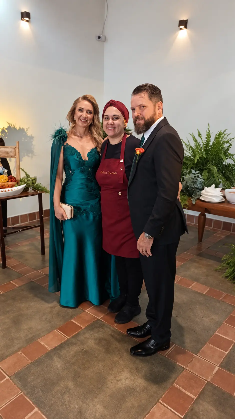 Emiliana ao lado de um casal em um evento